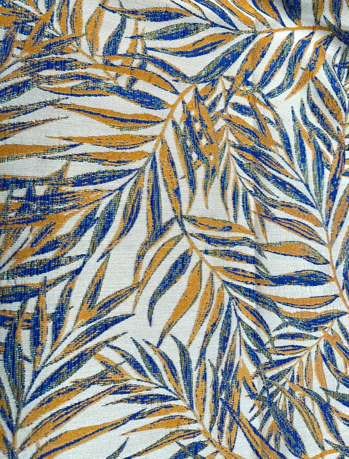 Vista superior de estampado de hojas de palma azul y mostaza en jacquard marfil