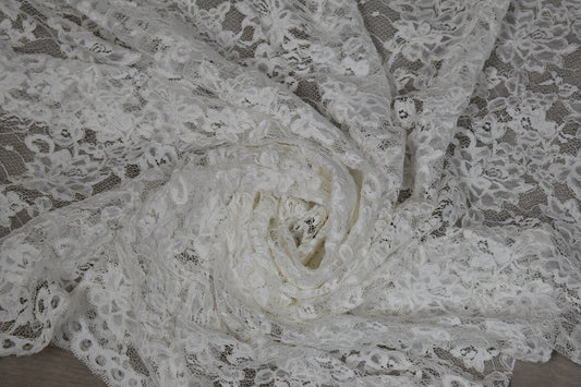 Encaje blanco con flores de cordón drapeado, mostrando su textura y transparencia
