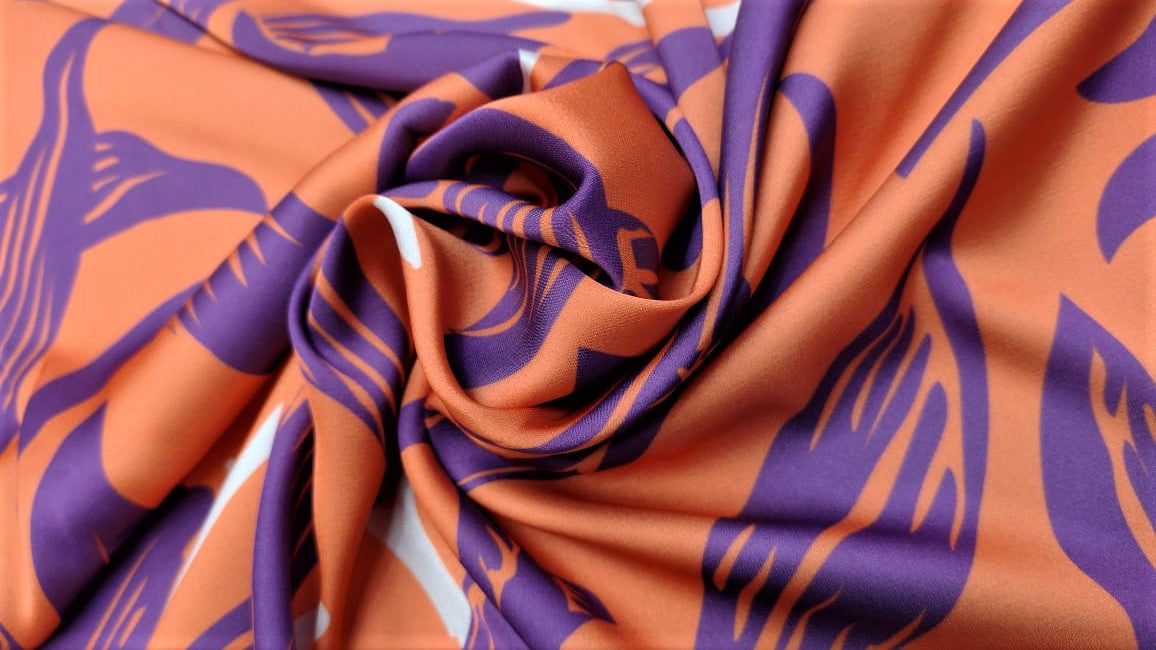 Seda francesa de hojas moradas sobre naranja salmón drapeada, mostrando su brillo y caída fluida