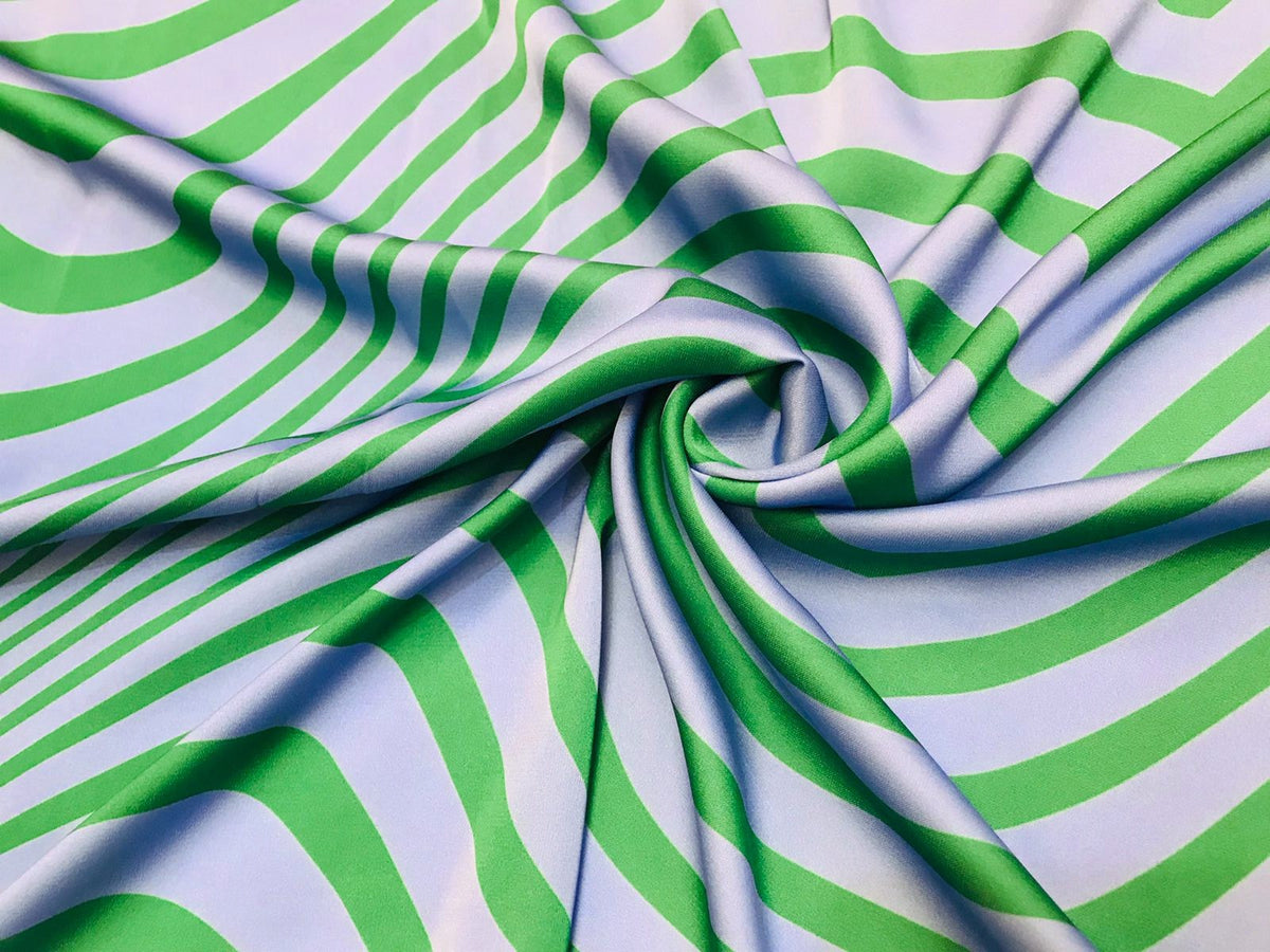 Seda francesa con ondas verdes sobre azul claro, drapeada, mostrando su brillo y caída fluida