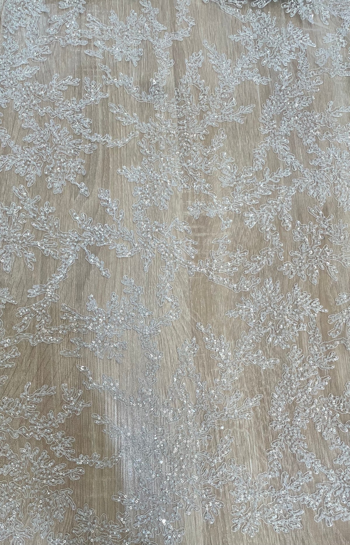 Tul bordado blanco con ramas tipo coral cubiertas de mostacilla y lentejuelas, vista general