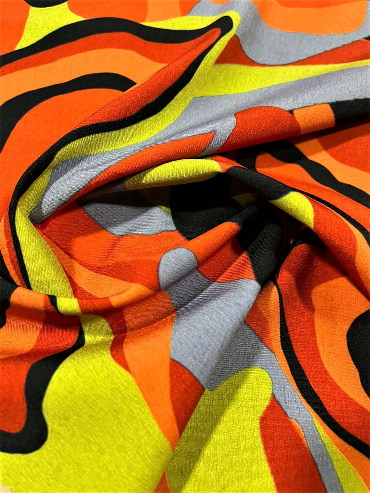 Seda francesa abstracta naranja y verde limón drapeada, mostrando su brillo y caída fluida