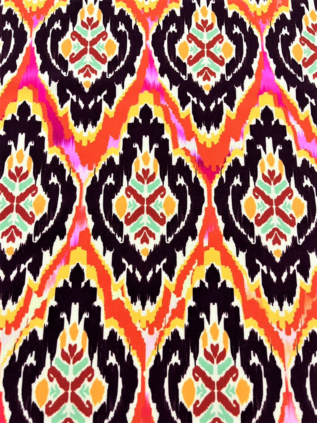 Detalle de seda francesa ikat con medallón vino oscuro y motivo floral rojo, mostaza y verde menta