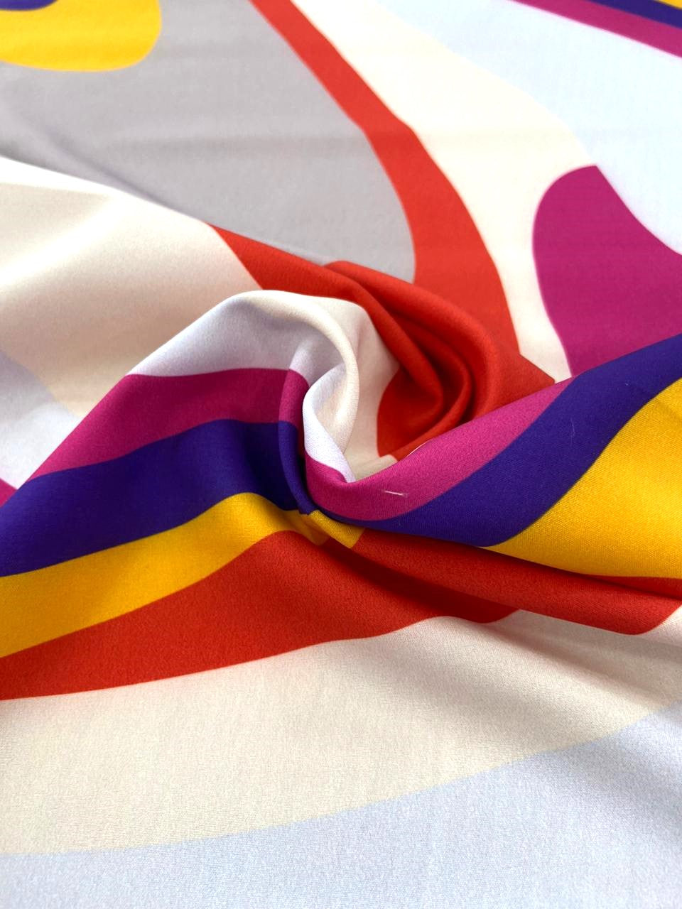 Seda francesa de ondas retro morado, rojo y amarillo drapeada, mostrando su brillo y caída fluida