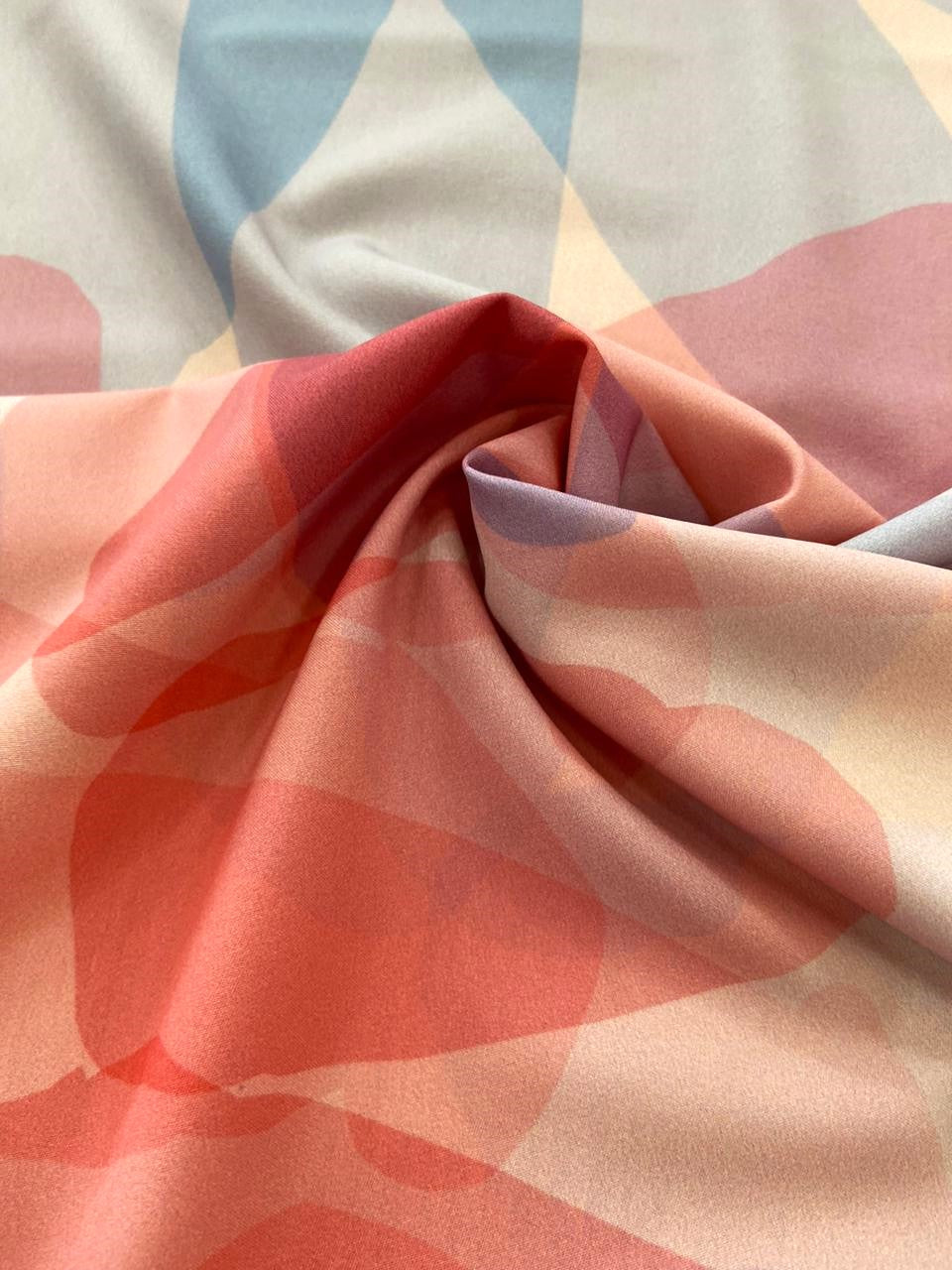 Seda francesa acuarela coral, rosa y azul grisáceo drapeada, mostrando su brillo y caída fluida