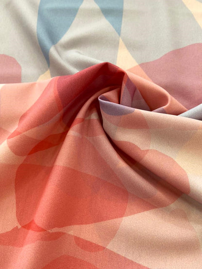 Seda francesa acuarela coral, rosa y azul grisáceo drapeada, mostrando su brillo y caída fluida