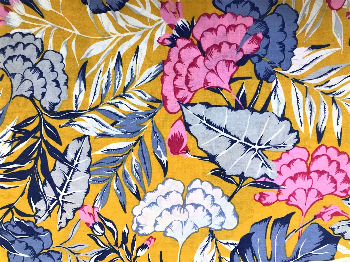 Vista superior del estampado floral botánico en popelina mostaza, azul y rosa