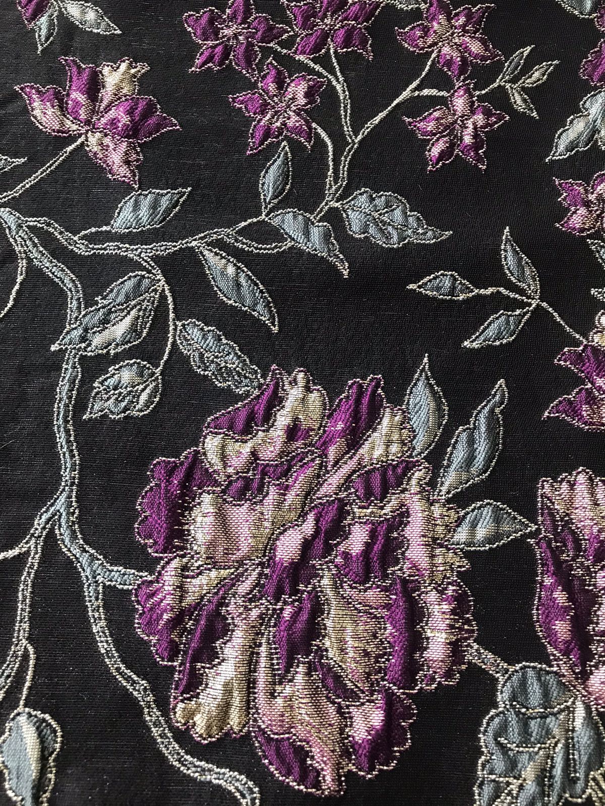 Primer plano de ramas y hojas con hilo metalizado plateado en jacquard negro floral