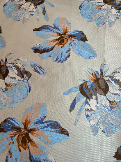 Primer plano de textura satinada y flor en jacquard gris con drapeado
