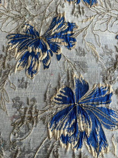 Vista superior de estampado floral azul rey y dorado en jacquard sobre fondo claro