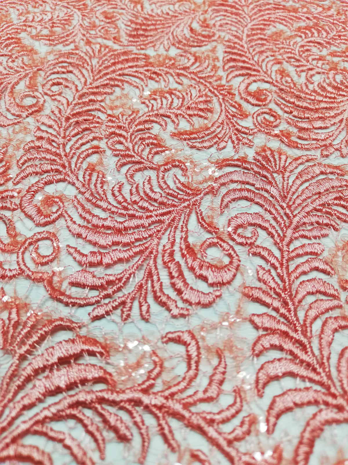 Detalle de encaje coral con plumas tipo helecho y lentejuelas 